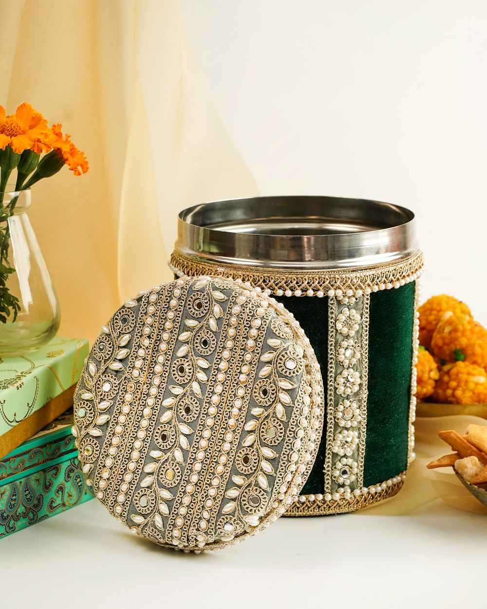 Baagh Velvet Ladoo/Bhaji Box | Navka A Baagh Velvet Ladoo/Bhaji Box by Navka Studio in green velvet, open, showcasing its ornate lid with pearls, mirrors, and embroidery.