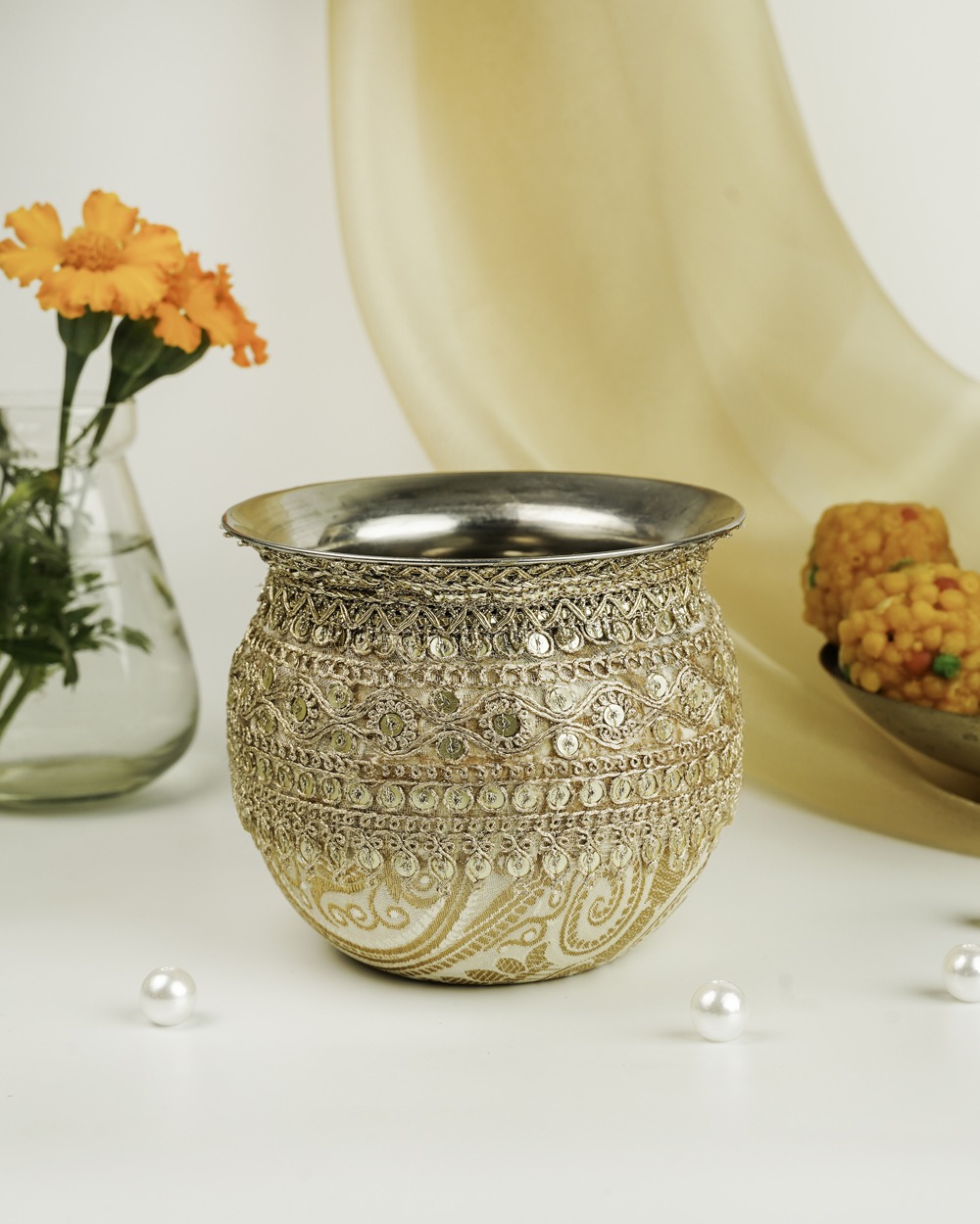 An elegant Noori Brocade Gadvi by Navka Studio, wrapped in cream and gold fabric, adorned with intricate lace and sequins.