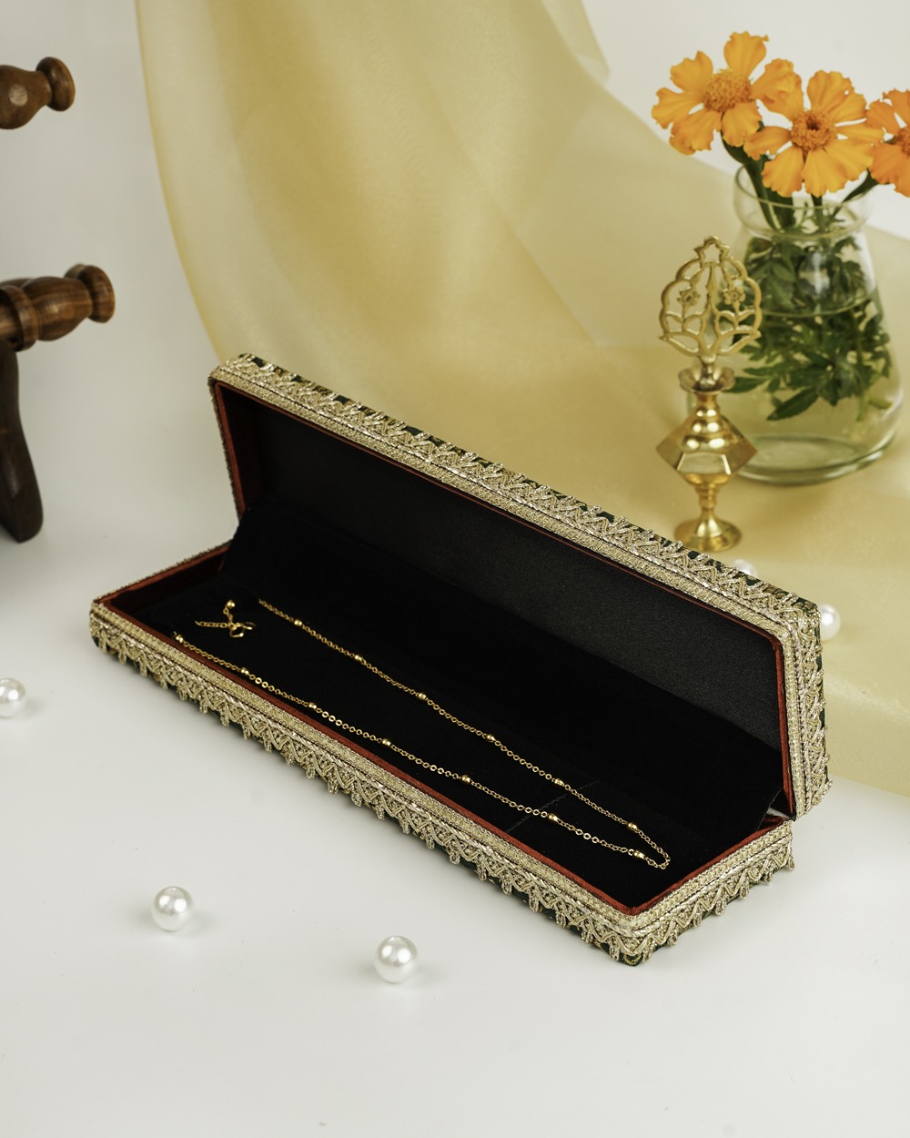 A Baagh Brocade Chain Box by Navka Studio, open to reveal a gold chain resting on its black velvet lining.