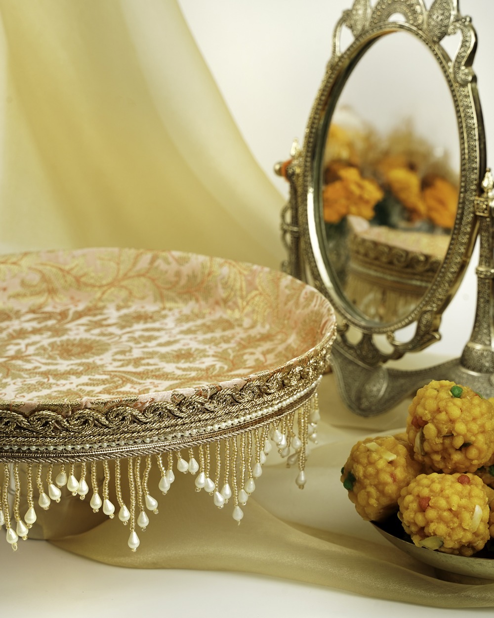 A beautiful angled view of the Meher Shagun Thaal with Cover by Navka Studio, showcasing its luxurious design, round shape, and pearl-fringed detailing.