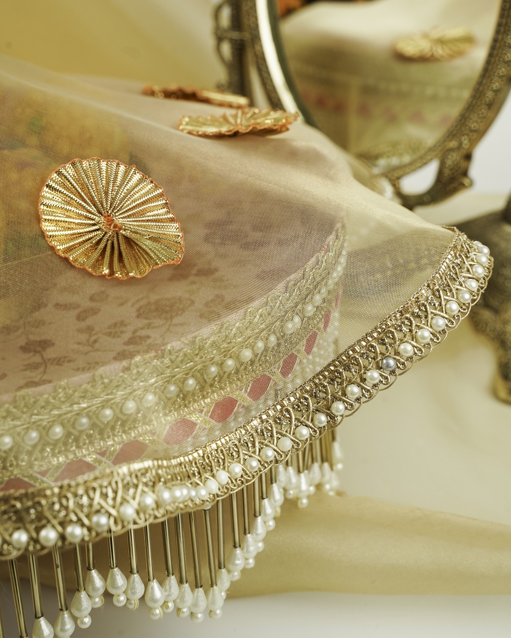 Bahaar Shagun Thaal with Cover for Wedding functions The Bahaar Shagun Thaal with Cover by Navka Studio, shown without the cover to display its round pink and gold floral brocade base and elegant pearl fringe, arranged in a festive setting.