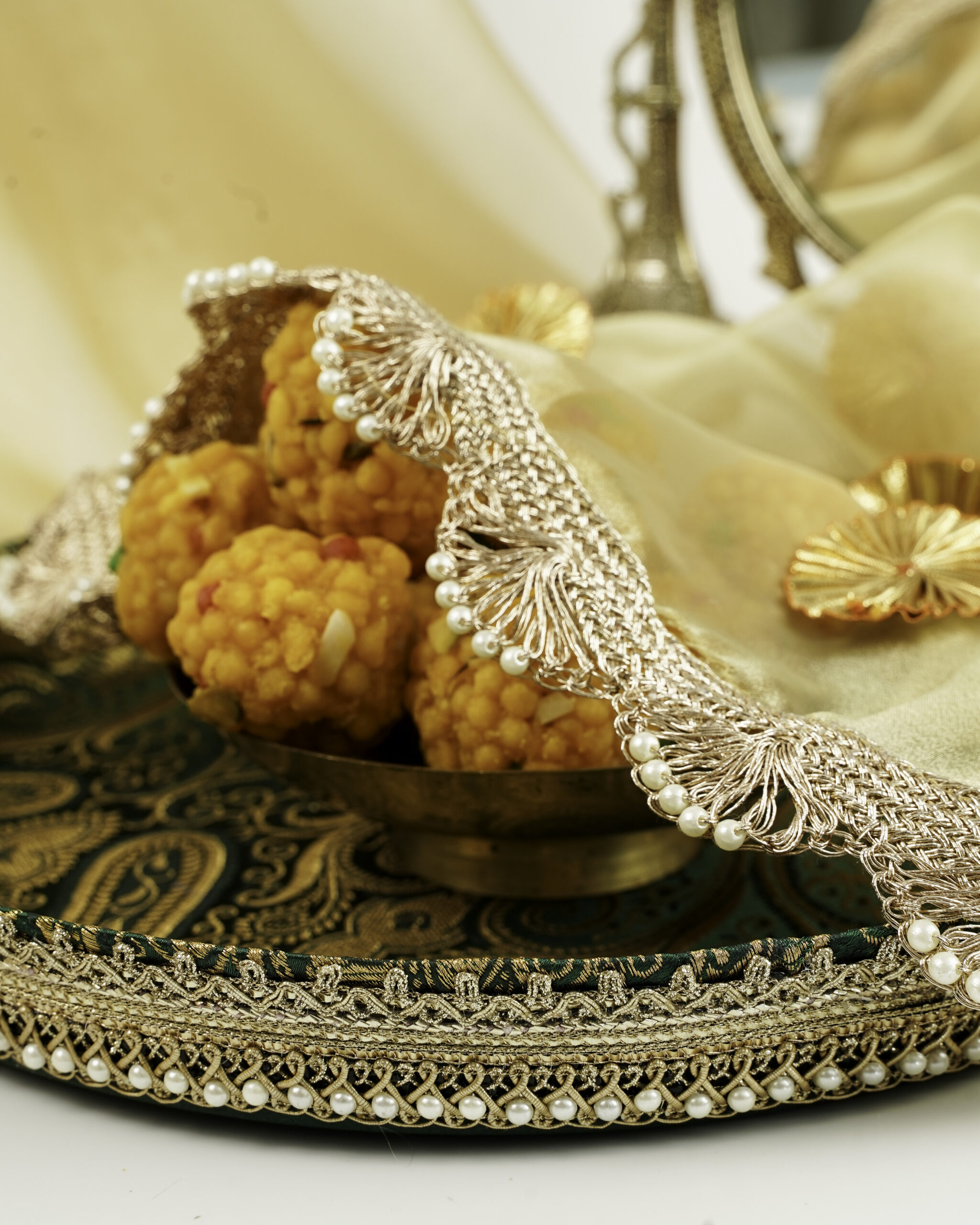 Baagh Shagun Thaal with Cover | Navka Studio A close-up of the Baagh Shagun Thaal with Cover by Navka Studio, showing its green paisley tray and sheer cover with pearl lace.