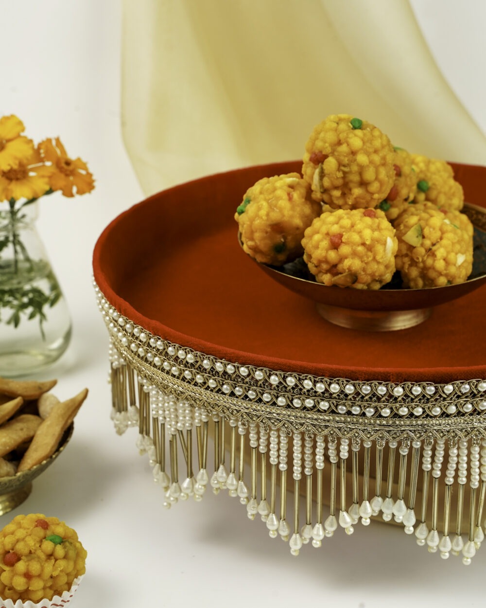 Navka Studio Sindoori Shagun Thaal with golden bowl of laddus, red velvet base, and ornate pearl-gold embellishments, ideal for festive and ritual use.