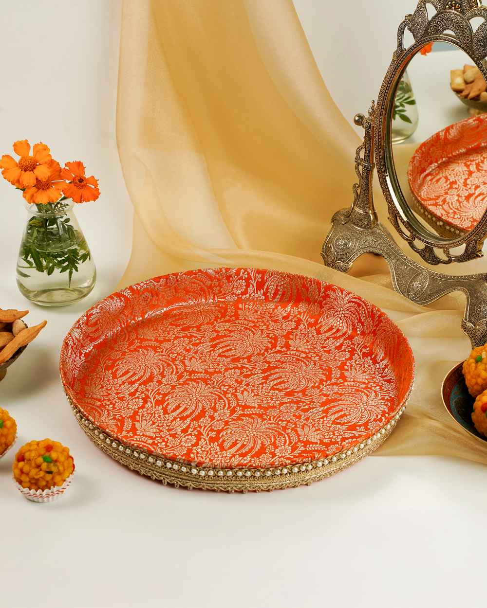 The orange brocade tray of the Sunehri Shagun Thaal with Cover by Navka Studio, featuring silver patterns and pearl trim.