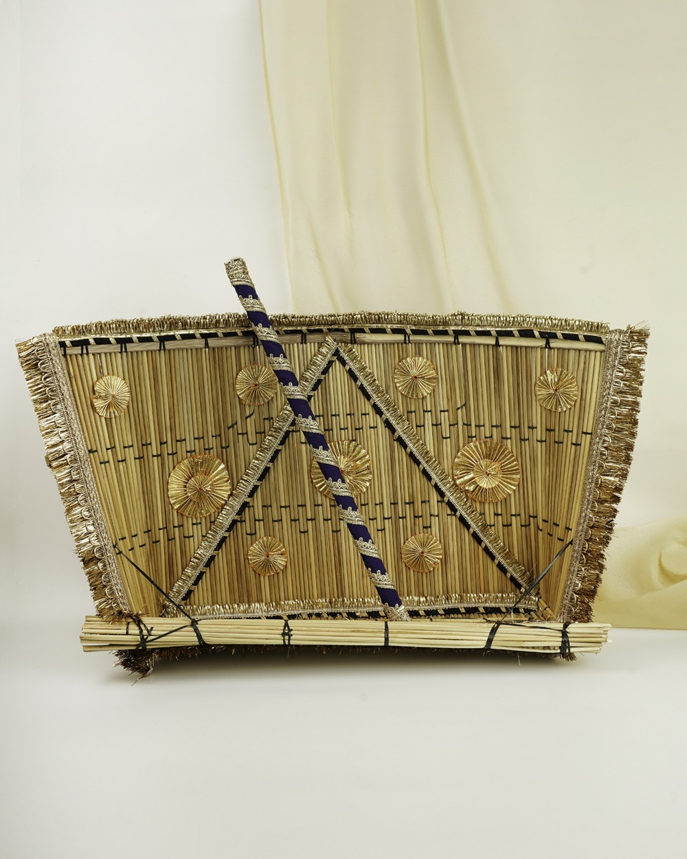 A traditional Chandni Chajj & Stick by Navka Studio, made of bamboo straws, decorated with gold gota patti and a navy blue stick.