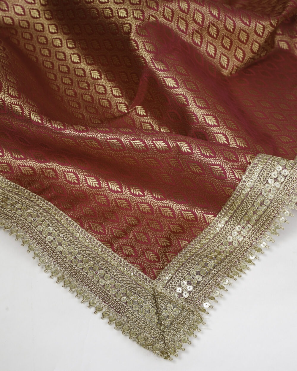 Sifat Rumala Sahib ,Close-up view of red and gold Sifat Rumala Sahib showing detailed golden embroidery and border design with shimmering fabric texture.