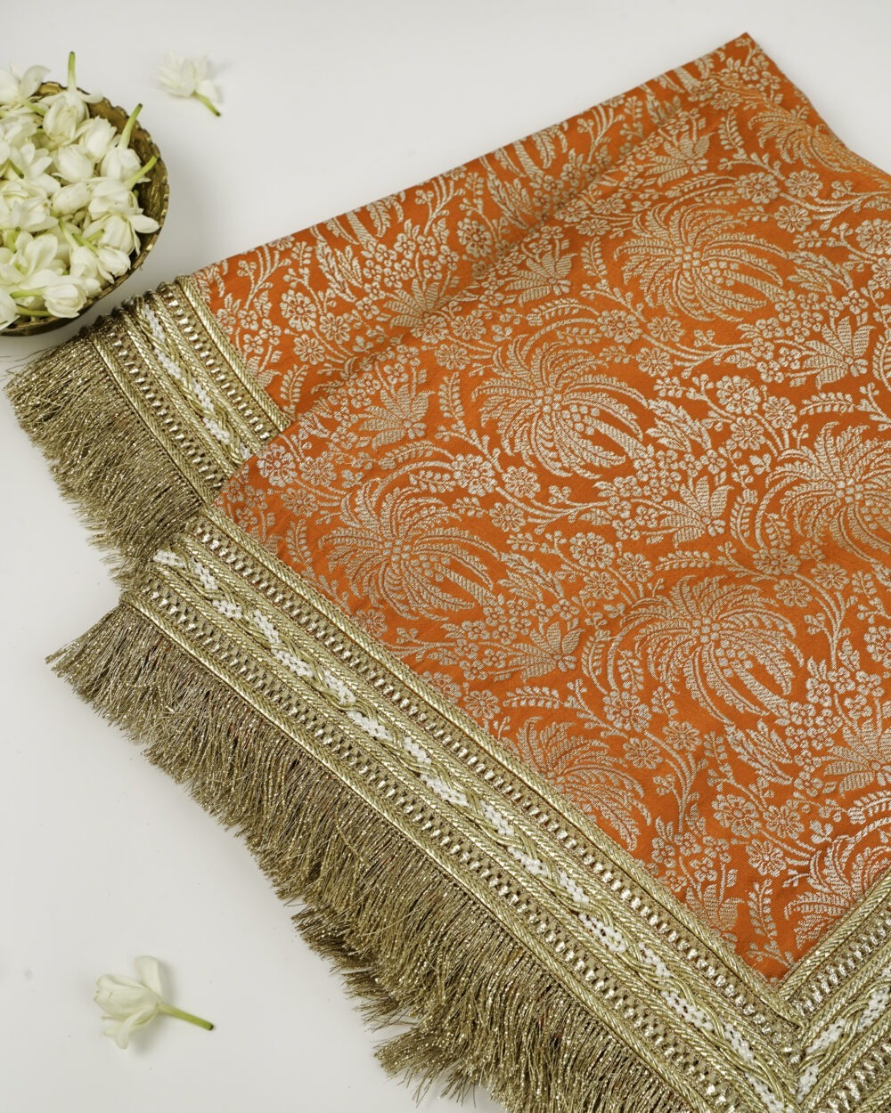 Suneheri Rumala SahibOrange and gold brocade fabric with intricate floral pattern and golden fringe border.