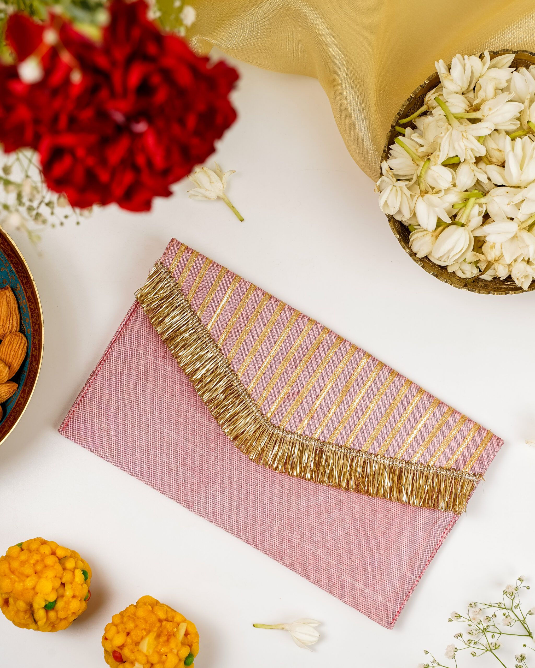 A dusty pink Navka Bahaar Gota Work Shagun Envelope featuring a gold-striped flap with a matching tassel fringe.