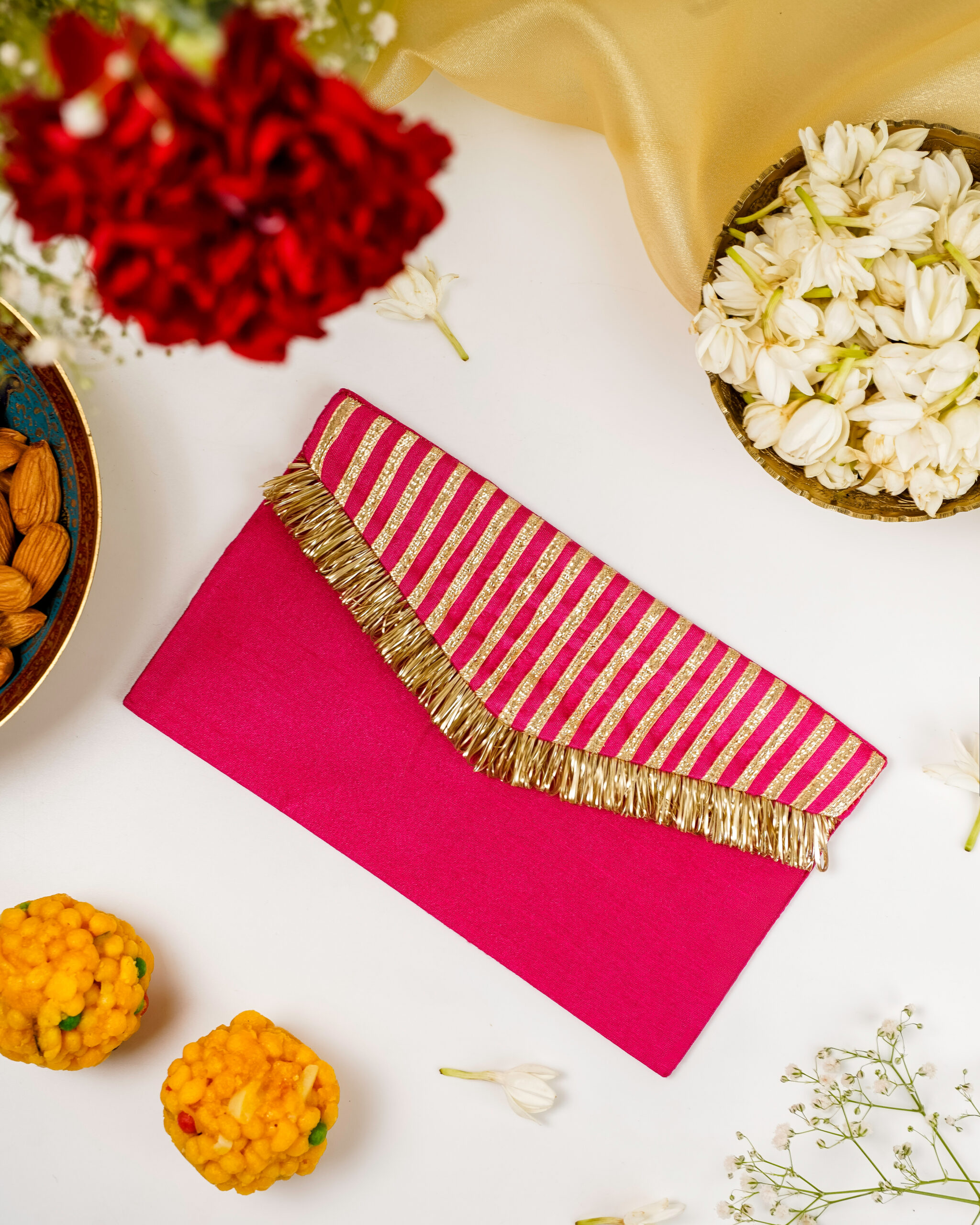 Navka's pink Gulzaar Gota Work Shagun Envelope with gold gota stripes and tassel fringe.